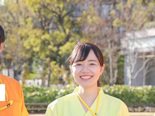 屋外で笑顔の職員  
