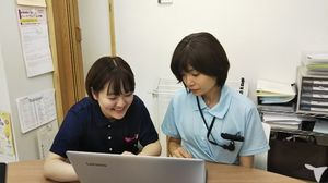 笑顔でパソコンを見るスタッフ