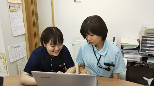 笑顔でパソコンを見るスタッフ
