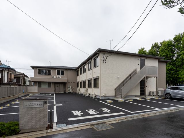 入り口のある建物外観 外観 広々とした駐車場を備えた建物です。アクセスが良好で、通いやすい環境が整っています。