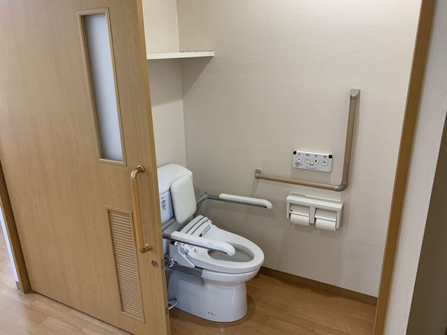 快適なトイレ空間 トイレ 使いやすい設計のトイレには、手すりがあり安心して利用できます。清潔感が大切にされています。