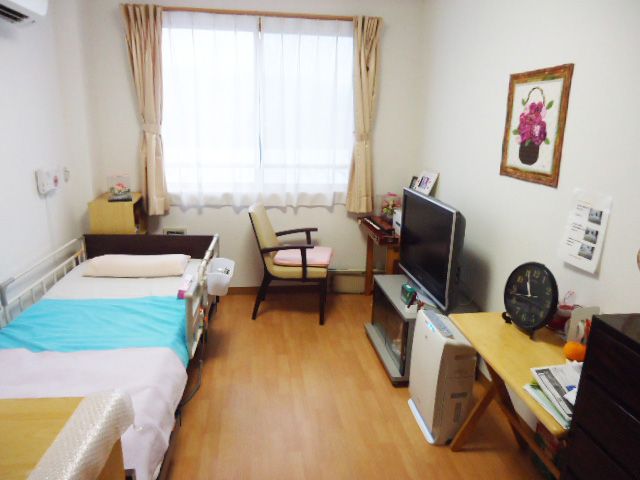 居室の明るい空間 居室 ゆったりとしたベッドと個性的な装飾が施された居室です。窓からの自然光が心地よい雰囲気を作り出しています。