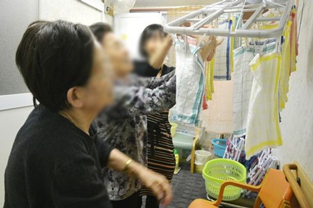 洗濯物を干す様子の室内 コインランドリー 施設内には広いコインランドリースペースがあり、効率的に衣類の乾燥ができます。