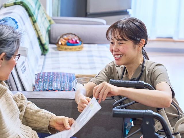 温かい人との交流の場 リビング 温かみのある空間で、利用者とスタッフが笑顔で交流しています。リラックスしやすい雰囲気です。