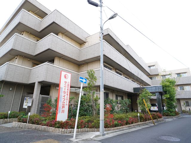 建物外観と看板 外観 清潔感のある建物外観が確認できます。緑豊かな周囲の植栽は、訪れる方々に安らぎを提供しています。