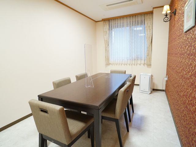 茶色のテーブルと椅子の居室 共有スペース 清潔感あふれる居室では、ゆったりとした時間をお過ごしいただけます。落ち着いた色合いの家具が、心地よい空間を演出しています。