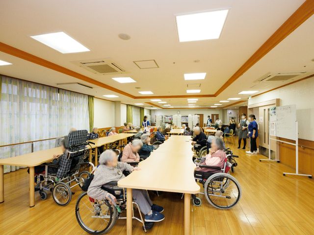 活動する人々の多目的室 食堂 明るい室内で様々な活動が行われる空間です。働く際の環境としても適しています。