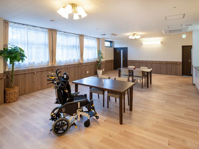 広い食堂と車椅子 食堂   大きな窓から光が入る、明るく広い食堂です。車椅子でも使いやすいゆとりがあり、食事や会話がしやすそうです。