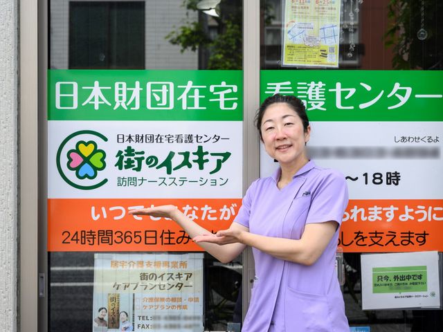 笑顔のスタッフ看板前 スタッフイメージ 明るい笑顔でお出迎えするスタッフが心地よい安心感を提供してくれます。