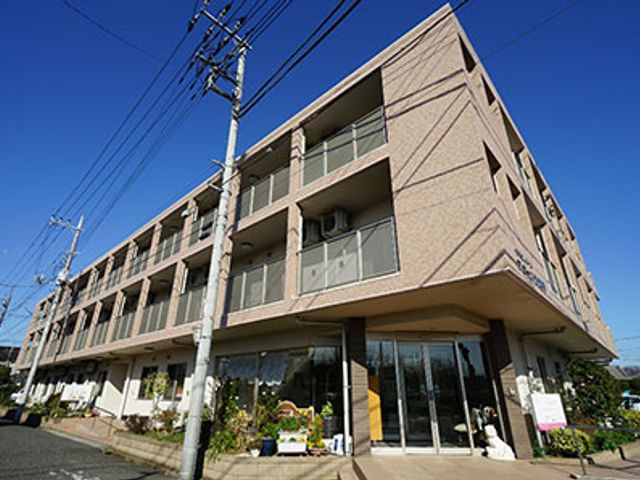 モダンな三階建て外観 外観 明るい空の下、モダンなデザインの三階建ての施設は働く魅力を感じさせます。