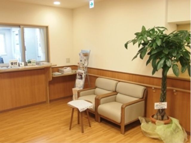 待合スペースの植物とソファ エントランスロビー 落ち着いた雰囲気のエントランスです。待合のソファで心地よい時間をお過ごしいただけます。