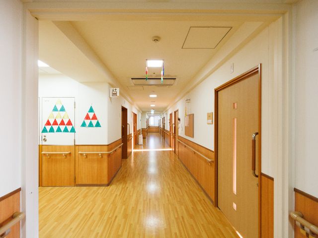 明るい廊下の風景 廊下 手すり付の温かみのある廊下は、ゆったりとした移動が可能です。手作りの壁装飾がアクセントになっており、心地よい雰囲気を演出しています。