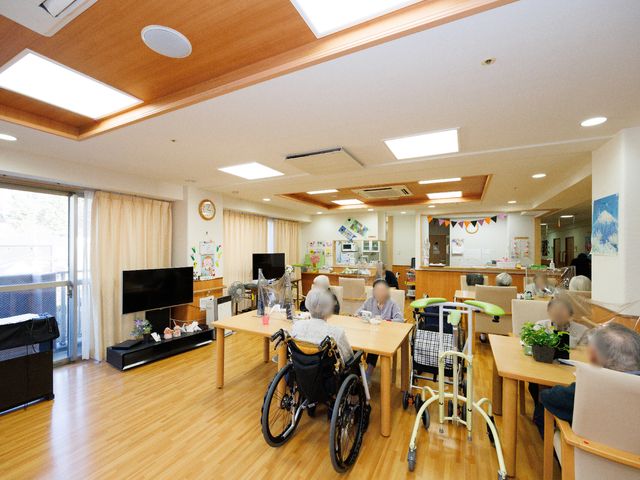 共有スペースでのひととき 食堂 広々としたラウンジでは、入居者の皆さんがテーブルを囲んで談笑されています。心地よい採光で明るく、スタッフの温かな対応も好印象です。