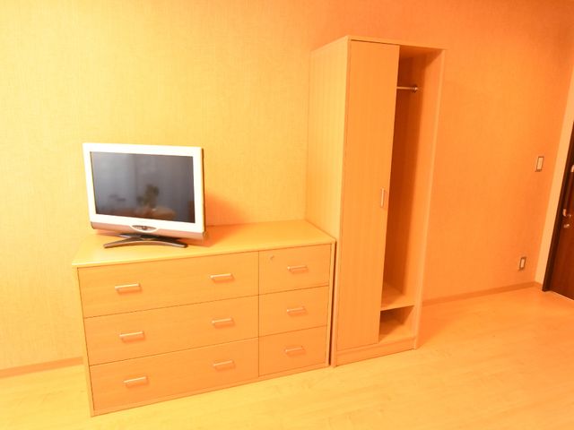 居室のテレビとクローゼット タンスとクローゼット 木目調の家具が温かみを感じさせる居室です。個々のスペースを大切にした、快適な生活環境が整っています。