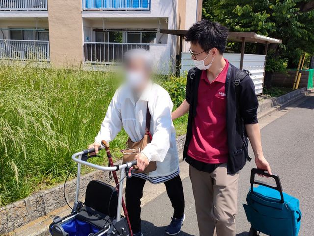 歩行補助の様子 外観 散歩中の様子で、スタッフが歩行をサポートしています。穏やかな時間が流れる場所です。