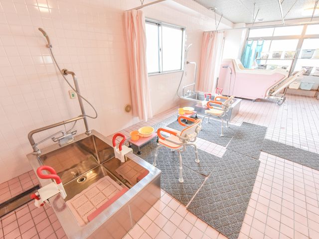 清潔な浴室設備 カーテンでプライバシーが守られる浴室 広々として明るい浴室です。利用者の安全と快適さを考えた手すりや椅子が備え付けられています。