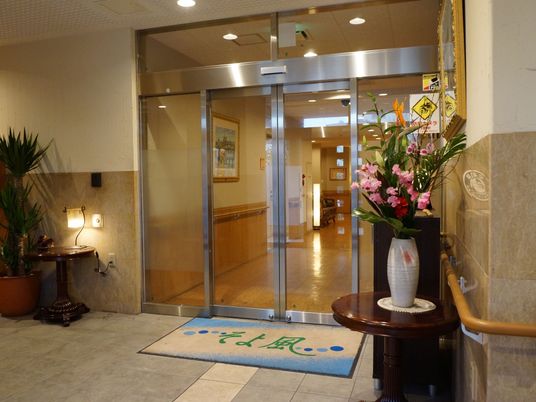 玄関のアプローチには花や調度品でおしゃれにレイアウトされている。扉は広く開閉する自動ドアになっている。