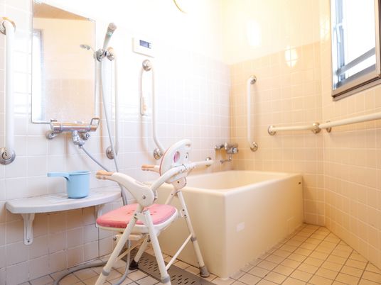 風呂場には壁に手すりが数多くついている。壁や床はタイル張りで背もたれの付いた椅子が置いてある。また、ナースコールも付けられている。
