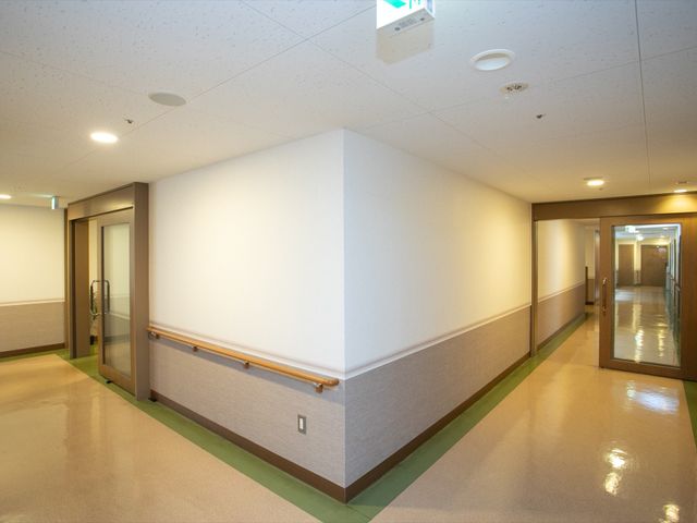 清潔感ある施設の廊下 廊下 手すりが備えられ、安全に配慮された明るい廊下です。スタッフや利用者の円滑な移動を支える設計となっております。