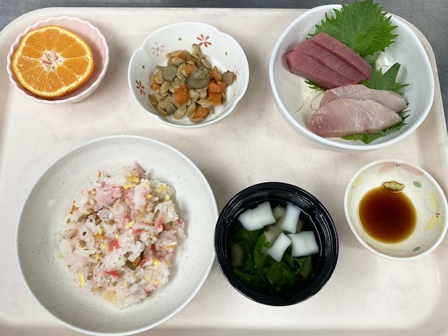 彩り豊かな食事の皿 料理 新鮮な刺身とカラフルなちらし寿司のセットは、見た目も楽しめます。季節の果物も添えられています。