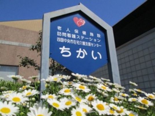 青い看板と花