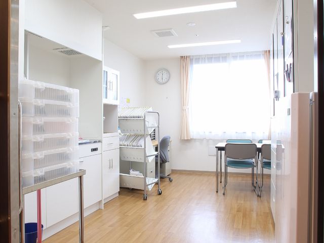 明るい機能訓練室 スタッフルーム 床材に木目調を採用し、温かみのある訓練室は、日光が柔らかく照らす明るい空間です。椅子や訓練器具も完備しており、快適にお過ごしいただけます。