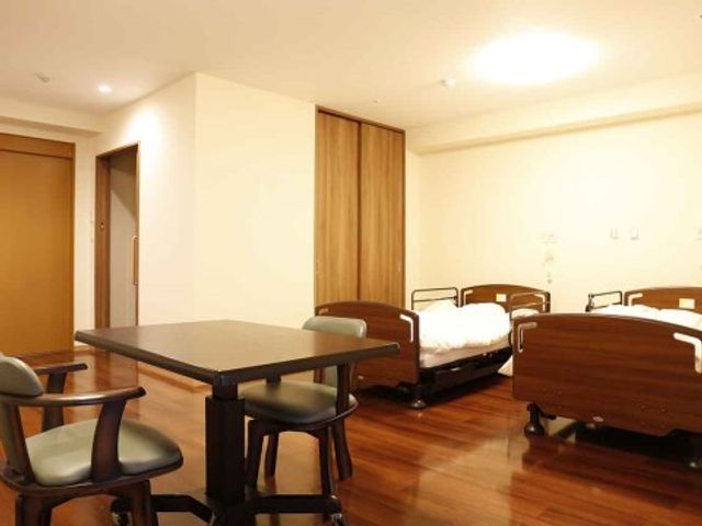 居室のテーブルとベッド 夫婦部屋３ ゆとりある空間の居室です。共有スペースにも近く、コミュニケーションがとりやすい配置になっています。
