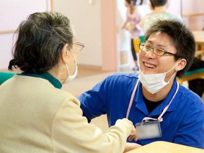 笑顔で手を握る介助者