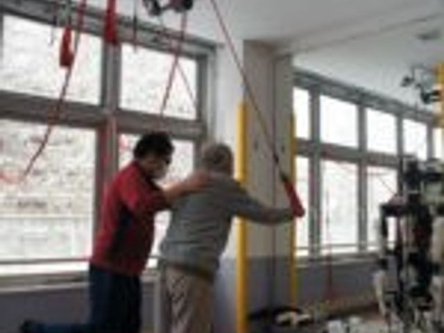 二人が訓練する機能訓練室 機能訓練室 広い空間で、二人が運動を通じて健康維持に励んでいます。自然光が入る快適な環境です。