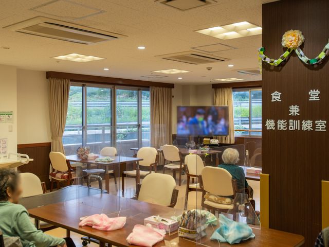 共有スペースの居心地の良さ 食堂兼機能訓練室 広々として明るい共有のスペースでは、ご入居者が一息つきながら、くつろいだ時間を過ごしています。