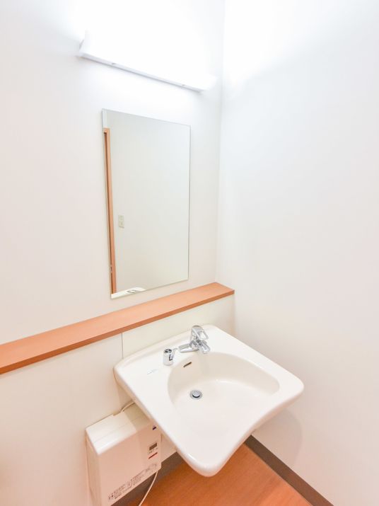 私室の手洗い場はシンプルながら蛇口の他に鏡も設置されており照明は一つですが壁の白さもあり明るく感じられます。
