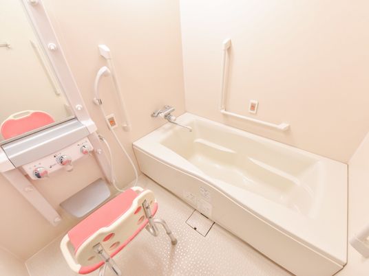 お風呂場は蛇口とシャワーの切り替えが簡単にできるタイプなので利用しやすい。壁には手すり、椅子も設置されている。