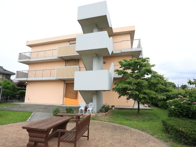 中庭のある建物外観 外観 木陰とベンチが備えられた中庭は、ゆったりとした時間を外で過ごすのに理想的です。