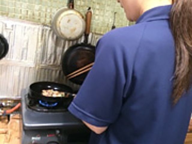 調理中のスタッフイメージ キッチン 手際よく食事を準備しているスタッフの姿が印象的です。安心してお食事をお楽しみいただける環境が整っています。