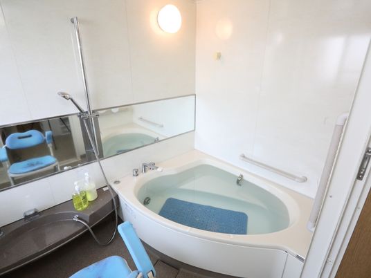 浴室は明るい色合いに統一されている。湯船の中には入居者がすべらないように、滑り止めシートが敷かれている。