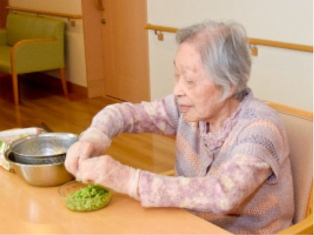 お料理を楽しむ利用者の様子 レクリエーション 穏やかな食堂で料理の準備をしている方の姿が見られます。手作りの温かみが感じられる空間です。