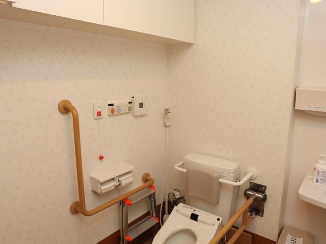 バリアフリーのトイレ 広々としたトイレ 手すり付きで安全性を考慮したトイレです。清潔感のある空間で、利用者の方々が快適に過ごせるよう配慮されています。