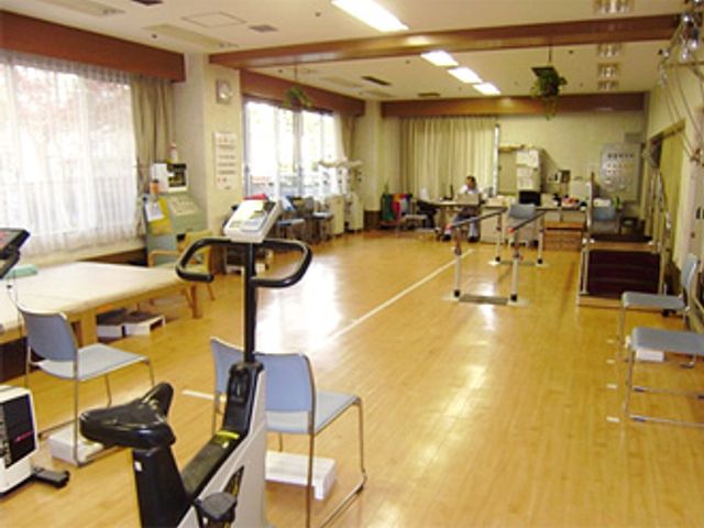 広いリハビリ室 機能訓練室 広々とした空間で、様々なリハビリ設備が整っています。自然光が差し込む明るい環境です。