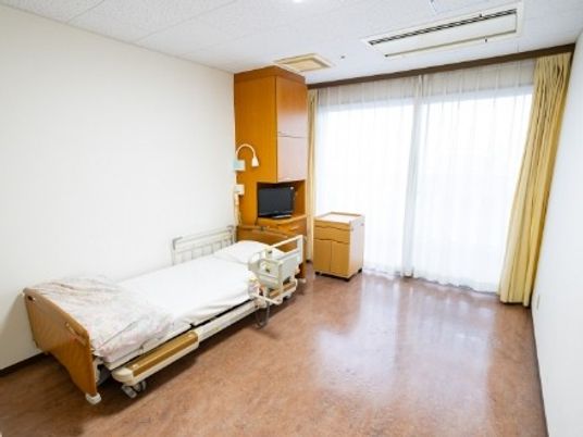 明るい居室のベッドと窓  