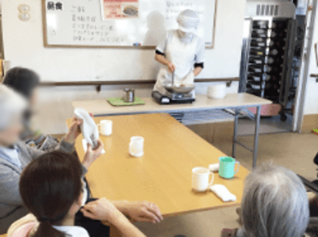 調理実演中のダイニングルーム ダイニングルーム 調理スタッフが食事の準備を進める様子を見学できます。居住者が交流を深める機会です。