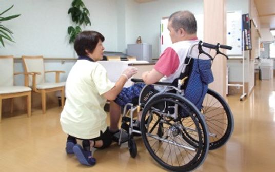 車椅子利用者とスタッフが対話する廊下