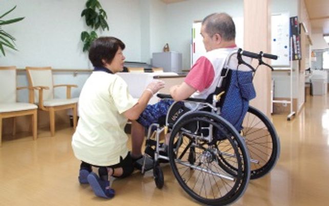 車椅子利用者とスタッフが対話する廊下