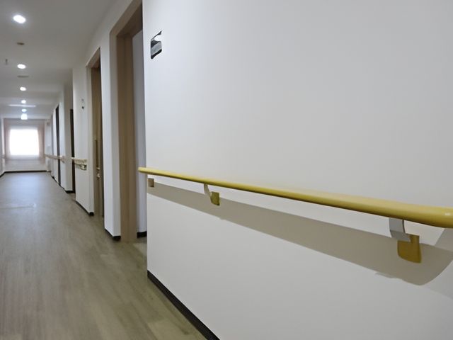 明るい廊下の手すり 廊下 壁沿いに取り付けられた手すりが、安全に配慮された廊下です。手すりを頼りに歩く方にとって、心強い環境が整っています。