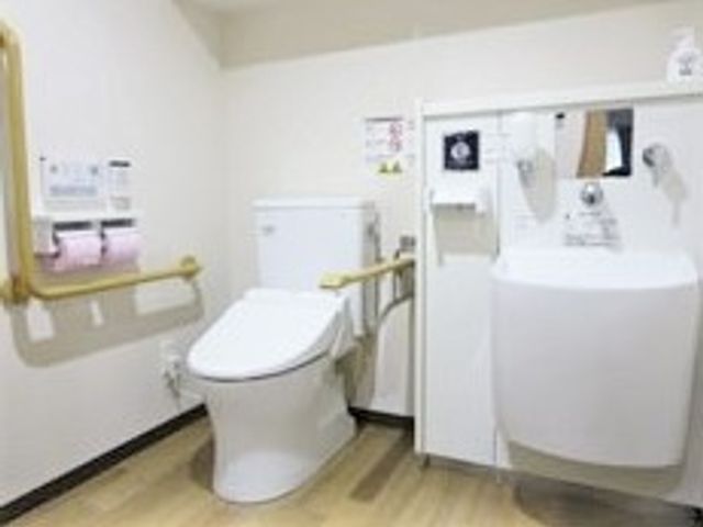 バリアフリーの洗面台とトイレ トイレ 手すり付きの安全設計トイレです。利用者の快適さを配慮した清潔な空間が保たれています。