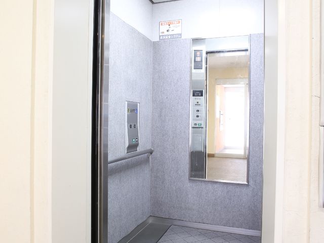 バリアフリー設計エレベーター 絨毯の敷かれたエレベーター スムーズな移動を支えるエレベーターです。ボタンが手の届く位置にあり、誰もが使いやすく考えられています。