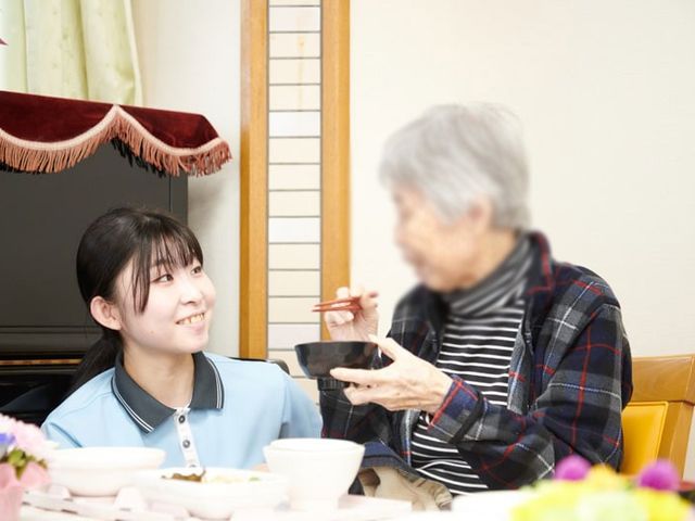 食事中の交流場面 ラウンジ 明るいラウンジで、利用者同士が楽しく交流しています。自然光が差し込み、暖かい雰囲気です。