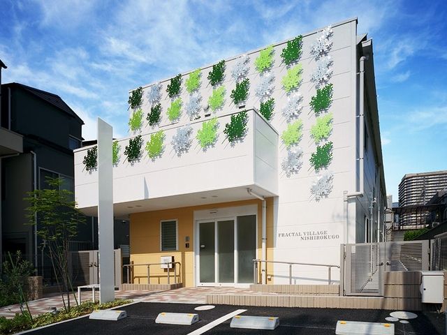 装飾のある建物外観 外観   白い外壁に緑の装飾が映える、すっきりした建物です。車寄せ前にゆとりがあり、出入りしやすい印象です。