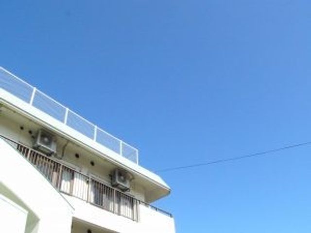 建物外観と青空の外観 外観   白い建物の上部と青空が見えます。明るく開放感のある印象で、働く場所の雰囲気が伝わります。
