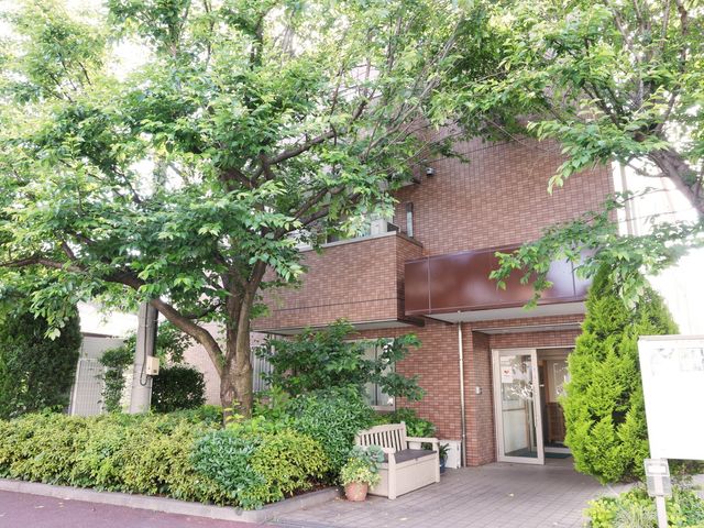 木々に囲まれた建物のエントランス 外観 緑豊かな門扉から一歩足を踏み入れれば、安らぎを感じるエントランスが皆さまをお迎えします。
