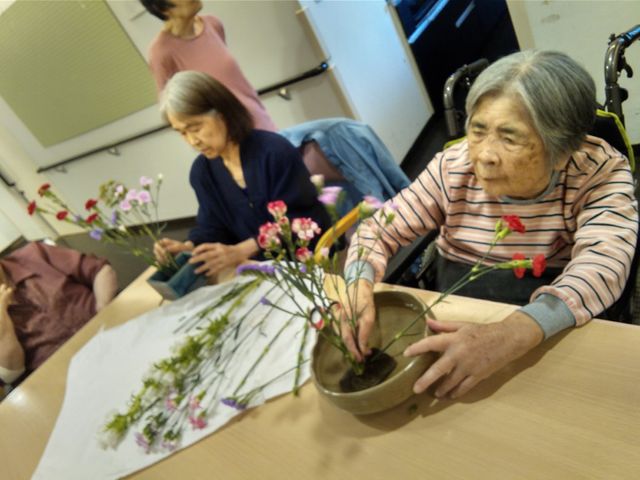 花を活ける様子 レクリエーション 皆で活ける花は、心を豊かにし和やかな交流の場を提供しています。